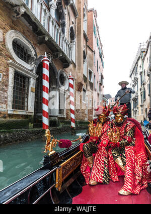 L'Italie, Venise. Deltaplane en gondole sur un canal étroit à Carnevale (MR) Banque D'Images