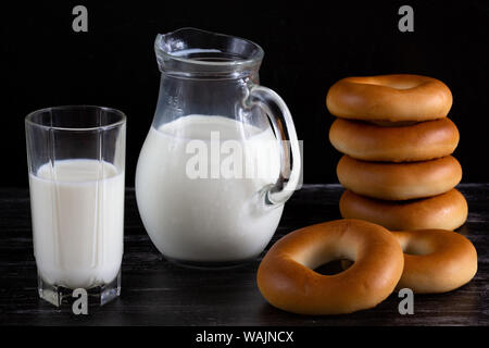 Pot à lait en pile et de bagels sur fond noir Banque D'Images