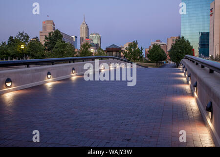 USA, White River State Park, Indianapolis, Indiana. La passerelle sur le canal à White River State Park est illuminée la nuit. Banque D'Images