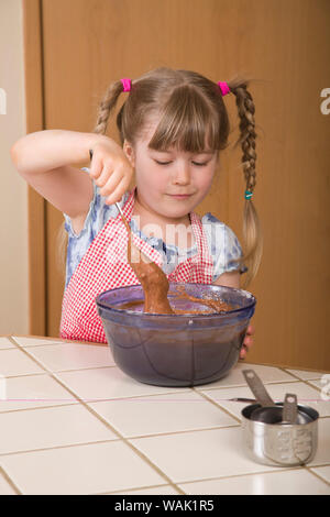 Girl en remuant la pâte d'un gâteau bundt chocolat. (MR, communication) Banque D'Images