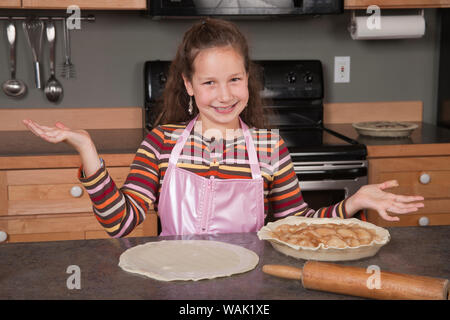 Girl montrant outre de la tarte aux pommes qu'elle fait. (MR, communication) Banque D'Images