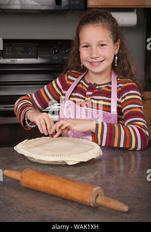 Sertissage de fille les bords de sa tarte aux pommes faite maison. (MR, communication) Banque D'Images