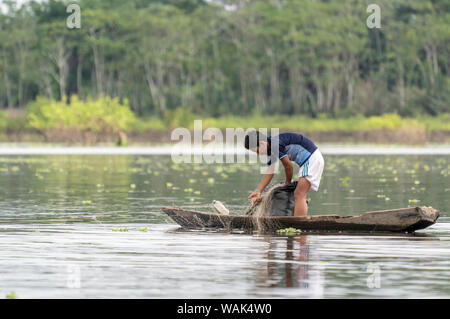 La réserve de Pacaya Samiria, Pérou. Jeune garçon vérifier ses filets de pêche dans la région de l'Ucayali River dans le bassin amazonien. (Usage éditorial uniquement) Banque D'Images