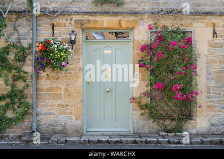 Maison de ville en pierre de Cotswold avec roses grimpantes et un panier suspendu sur la place du marché de Stow on the Wold, Cotswolds, Gloucestershire, Angleterre Banque D'Images