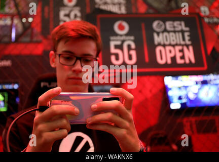 Cologne, Allemagne. Août 21, 2019. Lors de la gamescom, un employé Vodafone joue un jeu d'ordinateur sur un smartphone via le réseau 5G mobile. Les jeux d'ordinateur juste la Gamescom se tiendra du 20. au 24.08.2019 à Cologne. Credit : Oliver Berg/dpa/Alamy Live News Banque D'Images