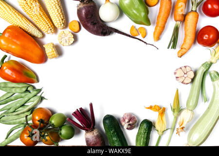 Mise en page créative faite de légumes d'automne. Les tomates, l'oignon, le concombre, la carotte, l'ail, poivre, betterave rouge, courgette, maïs et haricot vert sur bac blanc Banque D'Images