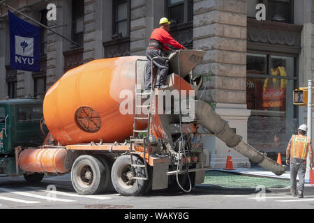 Une équipe de construction le coulage du béton et la rénovation d'un tronçon de trottoir sur Broadway dans Lower Manhattan, New York City. Banque D'Images