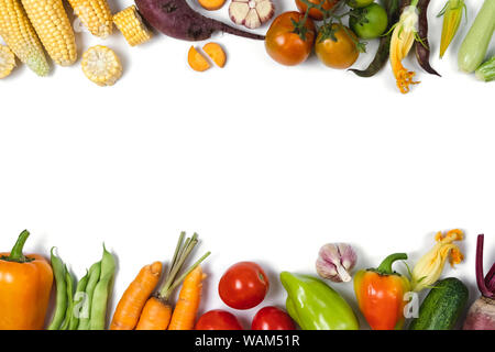 Mise en page créative faite de légumes d'automne. Les tomates, l'oignon, le concombre, la carotte, l'ail, courgettes, betteraves rouges, poivre, maïs et haricot vert sur bac blanc Banque D'Images