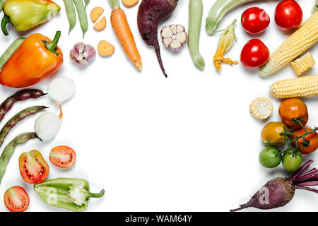 Mise en page créative faite de légumes. Concept de saine alimentation. Les tomates, oignon, carotte, ail, betterave rouge, poivre, maïs et haricot vert sur blanc zone Banque D'Images