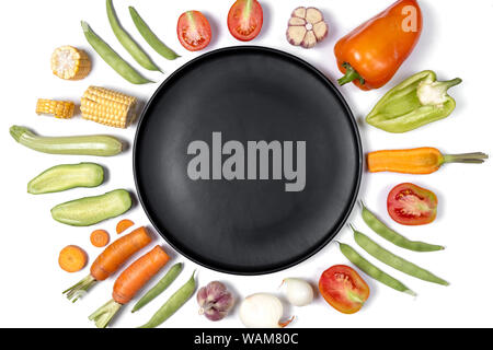 Mise en page créative faite de haricot, les tomates, le poivron, la carotte, l'ail, le maïs, la courgette, l'oignon et la plaque noire. Fond d'aliments biologiques. Mise à plat, vue du dessus, Banque D'Images