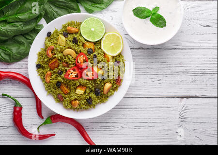 Biryani Panir aux épinards et au fond en bois blanc Raita avec décor. Panir aux épinards Biryani est végétarienne La cuisine indienne plat d'épinards, paneer, bas Banque D'Images