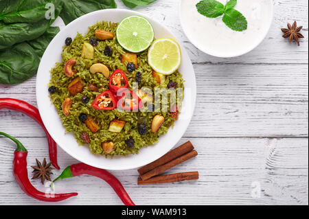 Biryani Panir aux épinards et au fond en bois blanc Raita avec décor. Panir aux épinards Biryani est végétarienne La cuisine indienne plat d'épinards, paneer, bas Banque D'Images