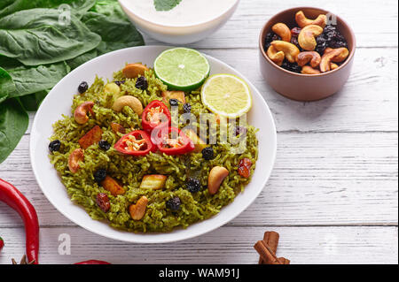 Biryani Panir aux épinards et au fond en bois blanc Raita avec décor. Panir aux épinards Biryani est végétarienne La cuisine indienne plat d'épinards, paneer chee Banque D'Images