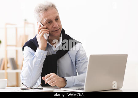 Mature businessman de parler avec le client, le travail à la maison Banque D'Images