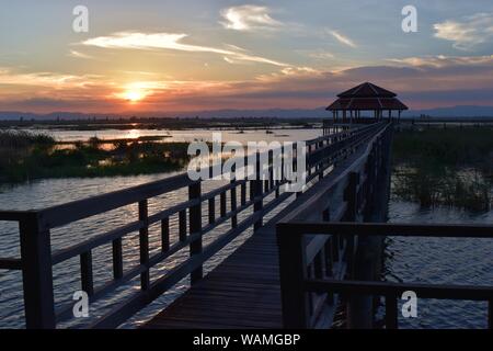 Khao Sam Roi Yot National Park, pont de bois et pavillon, sur le lagon, le ciel devient orange comme un coucher de soleil reflétant sur l'eau, Buang Bua , Thaïlande Banque D'Images