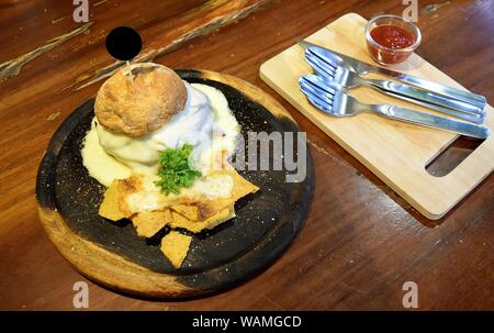 Burger au fromage et au jambon avec frites plaque sur un plateau en bois, de style japonais sur table marron Banque D'Images