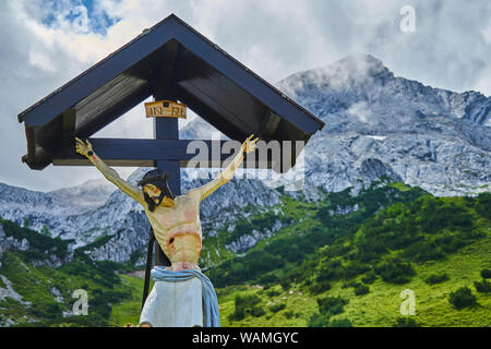 Garmisch-Partenkirchen, Allemagne, August 8, 2019 La vie. : taille de la main la figure de Jésus Christ sur une croix en bois avec un toit et le panorama de la W Banque D'Images