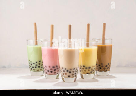 Boisson traditionnelle de l'Asie taiwan, verres de lait glace buble boba ou plateau avec de la paille sur fond blanc. Banque D'Images