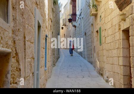Mdina rabat/une femme marche d'un sentier étroit malte Banque D'Images