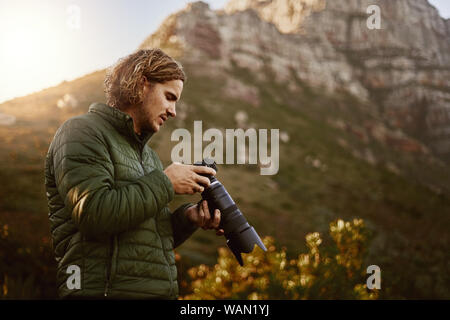 Contrôle photographe photos sur mirrorless appareil photo à l'extérieur dans la nature Banque D'Images