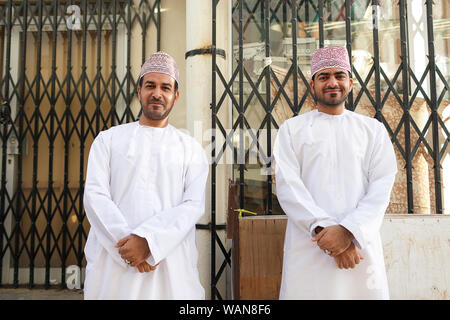 Deux hommes en vêtements traditionnels brodés à Sinaw portant chapeau de marché, Oman Banque D'Images