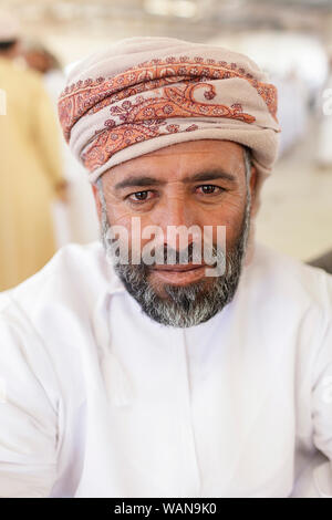 Portrait d'un homme avec une barbe et moustache en vêtements traditionnels portant un foulard à Sinaw, marché de l'Oman Banque D'Images