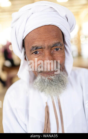 Portrait d'un homme avec une barbe et moustache en vêtements traditionnels portant un foulard à Sinaw, marché de l'Oman Banque D'Images