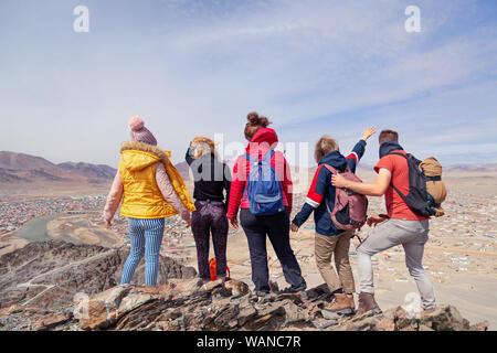 La Mongolie Ulgii 2019-05-04 Groupe touristique dans des vêtements colorés avec des sacs à dos randonnée, escalade, randonnée pédestre avec les pions de l'article en montagne, vue Banque D'Images