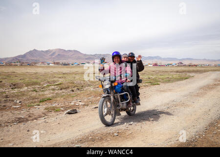 La Mongolie 2019-05-04 hommes mongole Ulgii ride moto à champ sur fond de steppe village ang vous saluent. Asiatique authentique Concept transpo Banque D'Images