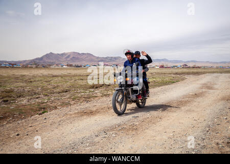 La Mongolie 2019-05-04 hommes mongole Ulgii ride moto à champ sur fond de steppe village ang vous saluent. Asiatique authentique Concept transpo Banque D'Images