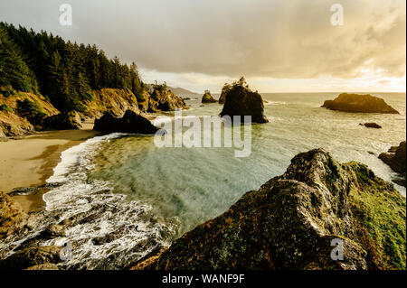Coucher du soleil sur la côte de l'Oregon avec botte de roches dans la distanc Banque D'Images