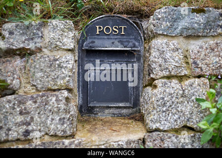 Il y a une vieille boîte aux lettres métal anglais intégré dans le mur de pierre. Banque D'Images