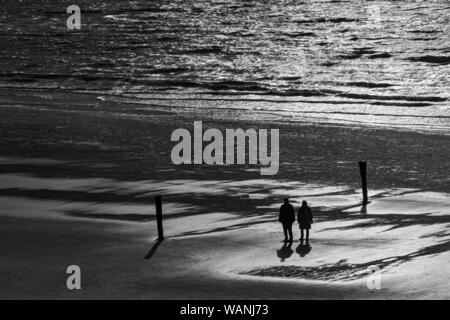 Le Relais Du Lac, Norderney, Strand, Spaziergaenger, Pfahl, Gegenlicht, Silhouette Banque D'Images