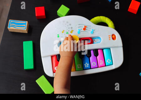 Bébé jouer et apprendre avec un piano jouet. Banque D'Images