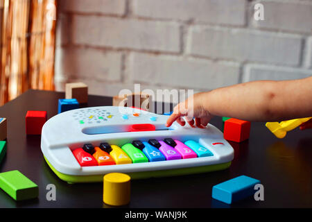 Bébé jouer et apprendre avec un piano jouet. Banque D'Images