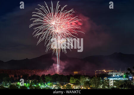 Un affichage rouge et blanc de pousses d'artifice au-dessus de Estes Park sur la quatrième de juillet. Banque D'Images