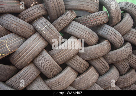 Contexte, la texture du mur de pneus mis à un angle. Caoutchouc de pneu noir, pièce du véhicule, pièce de rechange. Banque D'Images