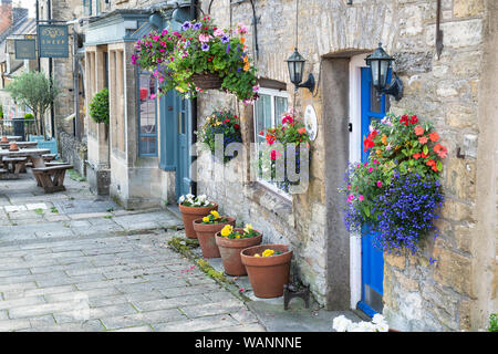 Paniers suspendus à l'extérieur d'un chalet à Sheep Street, Stow on the Wold, Cotswolds, Gloucestershire, Angleterre Banque D'Images