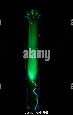 La foudre et des décharges électriques lumineux vert dans le ballon avec du gaz inerte sur un fond noir Banque D'Images
