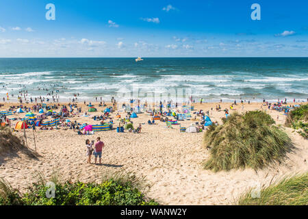 Vacanciers en vacances sur une plage ensoleillée de Fistral à Newquay, en Cornouailles. Banque D'Images