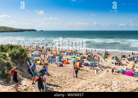 Vacanciers en vacances de vacances de vacances sur une plage ensoleillée de Fistral à Newquay en Cornouailles. Banque D'Images