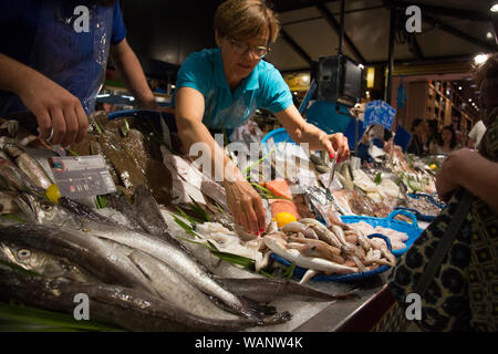 Un poissonnier à la vente du poisson à un étal au marché marché couvert Victor Hugo à Toulouse, France Banque D'Images