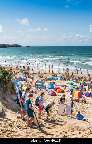 Vacanciers en vacances sur une plage ensoleillée de Fistral à Newquay, en Cornouailles. Banque D'Images