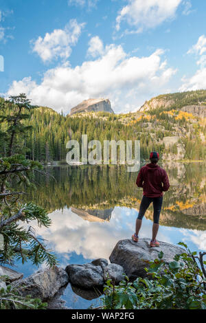Un randonneur s'arrête pour admirer la vue du lac de l'ours sur un après-midi d'automne dans la région de Rocky Mountain National Park, Colorado Banque D'Images