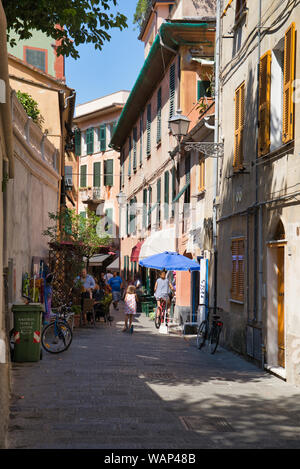 Sestri Levante, Italie - 16 août 2019 : Les gens de manger dans un petit restaurant à l'extérieur sur la terrasse au centre de l'ancien village de pêcheurs Banque D'Images