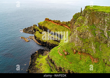 L'Irlande du Nord, Royaume-Uni. Falaises de la côte atlantique dans le comté d'Antrim avec strates géologiques visibles, et formation de basalte volcanique naturel de pol hexagonale Banque D'Images