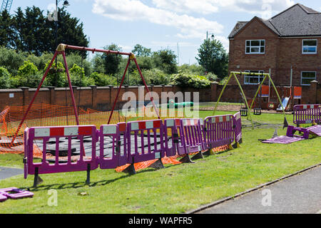 Un jeu d'enfant parc qui a été clôturé en raison de travaux de construction et d'amélioration de travail nécessaire pour rendre safeA child's play park qui a été clôturé de Banque D'Images