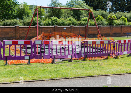 Un parc de jeux pour enfants qui a été clôturé en raison de travaux de construction et d'amélioration de travail nécessaire pour rendre sécuritaire Banque D'Images