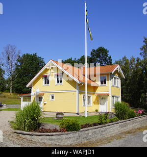 Maison traditionnelle suédoise à la campagne contre une décision partiellement nuageux ciel bleu. Banque D'Images