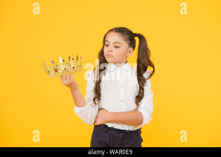 Faire son bal regarder super spécial. Une future reine du bal. Mignon petit enfant tenant couronne d'or pour l'école prom sur fond jaune. Adorable petite fille qui va à la nuit de bal. Banque D'Images